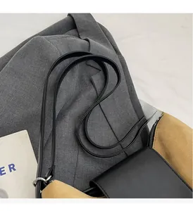 Detail of durable black leather handle and suede contrast on retro tote bag