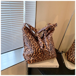 Detailed view of leopard print hobo bag with a knotted strap in a cozy interior setting