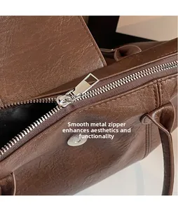 Close-up of smooth silver hardware zipper on a vintage dark brown leather tote bag