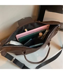 Detail view of large leather tote bag interior with multiple compartments and broad strap
