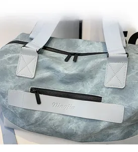 Detail showing smooth zipper and Ningjia logo on blue travel duffel bag material