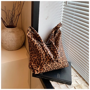 Detail of leopard print canvas tote bag with unique knotted handles in natural lighting