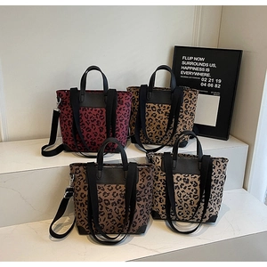 Detailed display of leopard print canvas tote bags in four versatile colors on marble steps