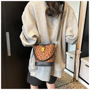 Detailed back view of a leopard print bucket bag with black strap and gold twist lock