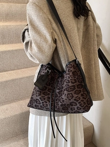 Chic leopard print bucket bag with drawstring closure and black leather straps