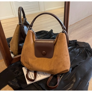Detailed view of brown suede convertible tote bag with leather flap and dual strap system