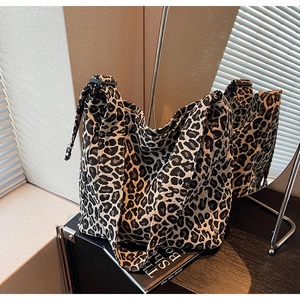 Vue détaillée du sac cabas en toile imprimé léopard avec une bandoulière épaisse noire