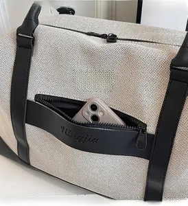 Close-up of canvas travel bag featuring a side zipper pocket and leather reinforcements