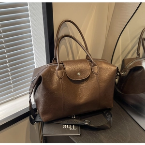 Close-up of brown PU leather Boston bag with vintage texture and stylish metal buckle