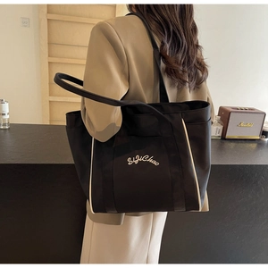 Detalle del bolso tote negro de gran capacidad con ribete blanco y texto SijiChao