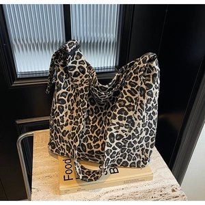 Gros plan détaillé du sac cabas en toile léopard sur une surface texturée en pierre