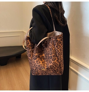 Close-up of leopard print velvet tote bag featuring a golden handmade metal plaque