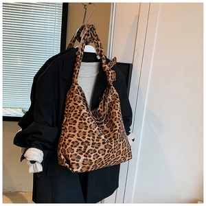 Detailed view of large leopard print hobo bag texture and wide strap on garment