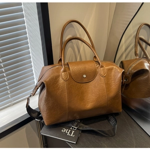 Detail of vintage brown tote bag showing matte texture and detachable fashion strap