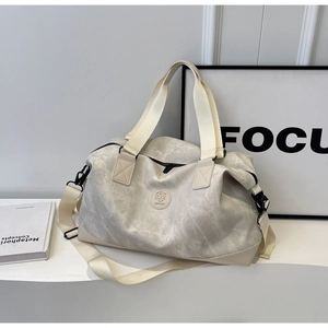 Macro view of water-wash textured travel bag with circular logo and webbing handles