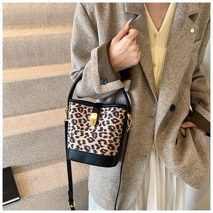Close-up of leopard print bucket bag with gold hardware and stylish long strap detail