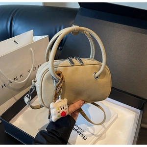 Détail du sac à bandoulière mat kaki avec pendentif ours dans un coffret cadeau