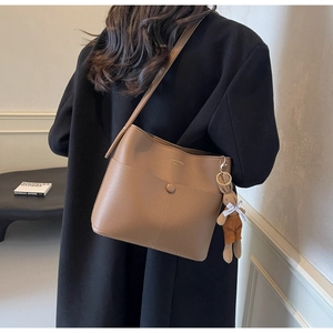 Brown litchi grain leather bucket bag with cute plush bunny pendant and gold logo