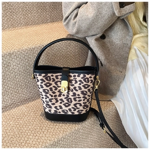 Detail of leopard print bucket bag with gold twist lock and black leather trim