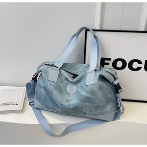 Close-up of light blue travel bag featuring water-resistant fabric and brand logo detail
