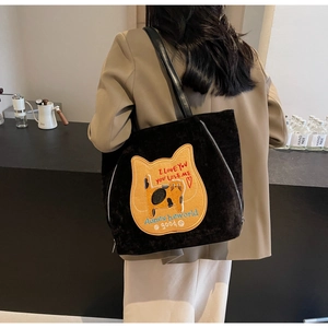 Dettaglio della borsa tote in velluto nero con una simpatica toppa ricamata con gatto
