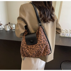 Close-up of leopard print tote bag with leather flap and decorative round buckle