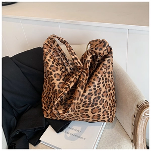 Detailed view of leopard print tote bag with wide shoulder strap and metal ring hardware