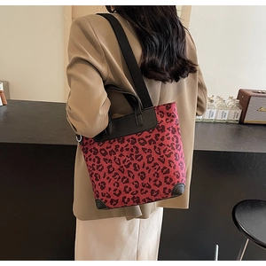 Detail of red leopard print tote bag with reinforced corners and adjustable shoulder strap