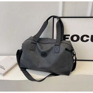 Macro shot of dark grey waterproof gym bag with reinforced straps on white podium