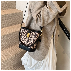 Detailed view of vintage leopard print bucket bag with gold lock and black leather trim
