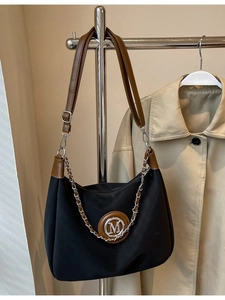 Vintage half-moon crossbody bag in black fabric with brown leather strap and metal M logo