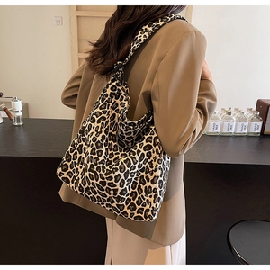 Vue détaillée d'un grand sac cabas en toile à motif léopard dans un café chaleureux