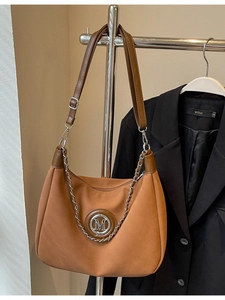 Retro brown suede crescent shoulder bag with metallic M logo and silver chain detail