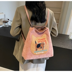 Dettaglio dello zaino in tela rosa con toppa a forma di gatto ricamata e testo