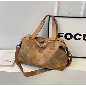 Detail view of large travel duffel bag in marble textured faux leather with wide shoulder strap