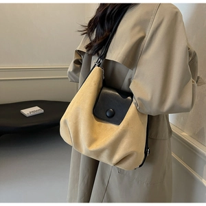 Detail view of large color-block tote bag in yellow and black with smooth matte leather