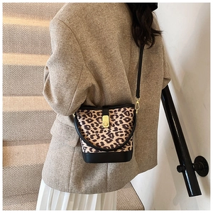 Detailed view of the leopard print bucket bag featuring a gold clasp and black leather trim