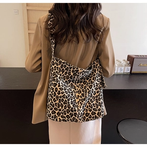 Détail du cabas en toile léopard avec large bandoulière porté sur un blazer kaki