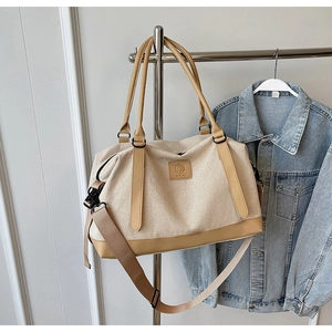 Détail du grand sac de voyage en toile avec finitions en cuir et bandoulière réglable