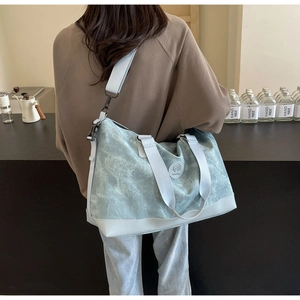 Detail of light blue marble textured travel bag with leather straps on model in cafe
