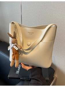 Chic cream litchi texture tote bag with plush bunny charm and magnetic front pocket