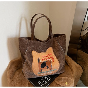Dettaglio della texture della borsa tote in velluto a coste marrone con ricamo a gatto