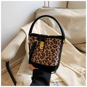 Detail of leopard print bucket bag with black leather trim and golden metal clasp