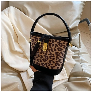 Detail of leopard print bucket bag with gold lock and black leather handle straps
