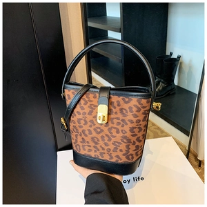Detail of leopard print bucket bag with black leather handle and gold metal lock
