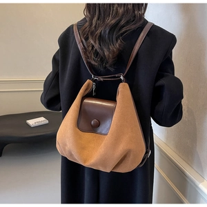 Close-up of dual-material tote backpack with suede texture and brown leather flap