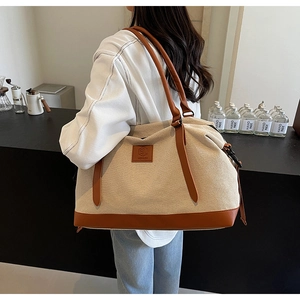 Vue détaillée arrière d'un grand sac cabas en toile avec poignées et base en cuir brun