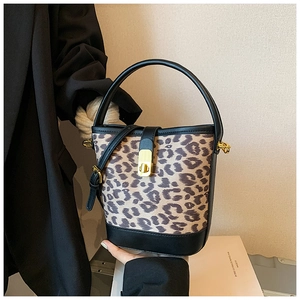 Detail of leopard print bucket bag featuring gold metal clasp and premium leather handle