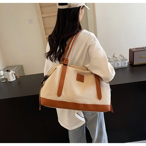 Détail d'un grand sac de voyage en toile crème avec finitions en cuir marron élégant