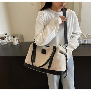 Détail du grand sac de voyage en toile avec base en cuir et bandoulière réglable